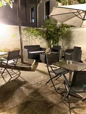 a patio with a table and chairs and an umbrella at LE PORTE DI PALERMO in Palermo