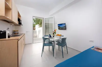 a kitchen and dining room with a table and chairs at Vitop Residence in San Vito lo Capo
