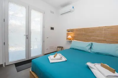 a bedroom with a blue bed with towels on it at B&B Lo&G in Lascari