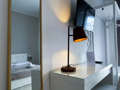 a room with a tv and a dresser with a lamp at Leone Suite B&B & Restaurant AIC in Palermo