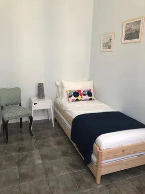 a bedroom with a bed and a chair at Sammartino 108 in Palermo