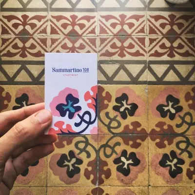 a person holding a card in front of a tiled floor at Sammartino 108 in Palermo