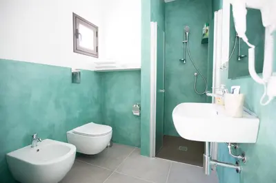a bathroom with a white sink and a toilet at White Asses Rooms in Castellammare del Golfo