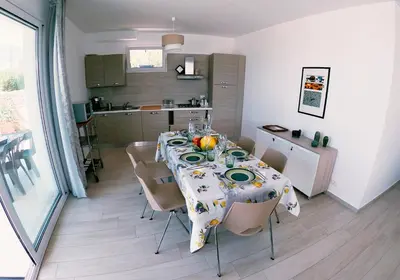 a dining room table with chairs and a kitchen at Villa Laurum - Giardino degli allori - Castellammare del Golfo - Scopello in Castellammare del Golfo