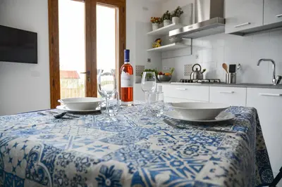 a kitchen with a table with plates and wine glasses at Casa Pomelia in Castellammare del Golfo