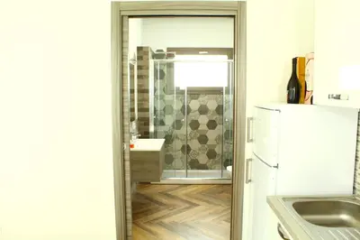 a kitchen with a glass door leading to a shower at Suite Capaci in Capaci