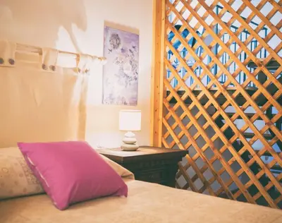 a bedroom with a bed and a table with a lamp at La casetta in Terrasini
