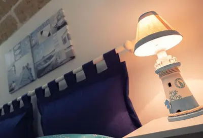 a lamp sitting on a table next to a bed at La casetta in Terrasini
