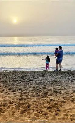 a man and two children standing on the beach at La casetta in Terrasini