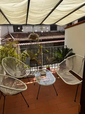 a patio with three chairs and a glass table and chairs at Mau House 44 Apartment in Palermo