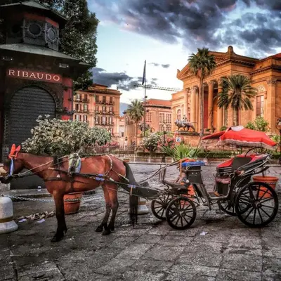 a horse pulling a carriage in front of a building at Casa Rdue a quiet historic center of Palermo in Palermo