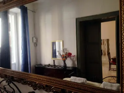 a mirror in a room with a table and a vase of flowers at Casa Rdue a quiet historic center of Palermo in Palermo