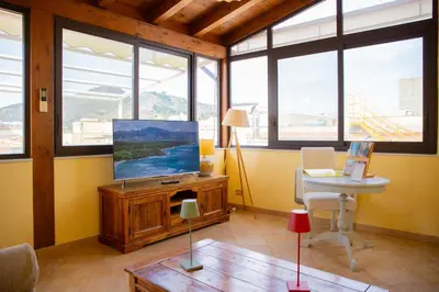 a living room with a tv and a table at Solemar Sicilia - Casa Enza in Santa Flavia