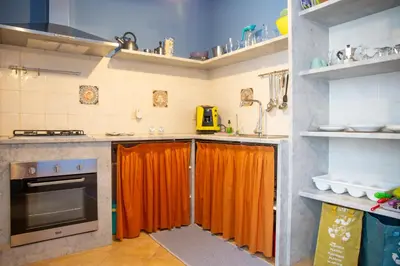 a kitchen with an orange curtain on the counters at Solemar Sicilia - Casa Enza in Santa Flavia
