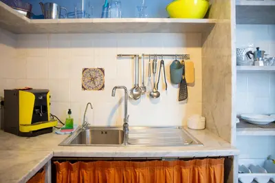 a kitchen with a stainless steel sink and utensils at Solemar Sicilia - Casa Enza in Santa Flavia