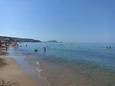 a group of people in the water at a beach at Torre Vallelunga in Trabia