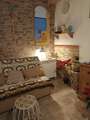 a living room with a bed and a stone wall at Torre Vallelunga in Trabia
