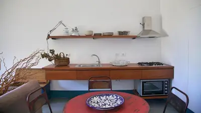 a kitchen with a counter and a sink and a table at Casa Nonnona in Palermo