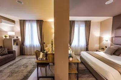 a hotel room with a bed and a desk in a room at Delle Vittorie Luxury Rooms&Suites in Palermo