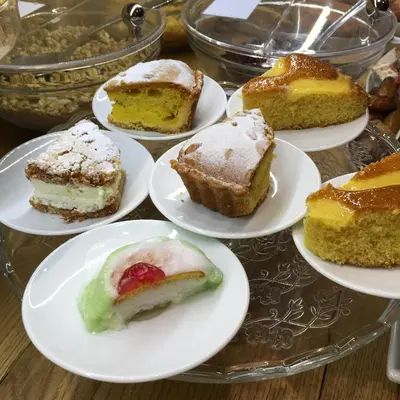 a bunch of different types of cakes on plates on a table at Delle Vittorie Luxury Rooms&Suites in Palermo