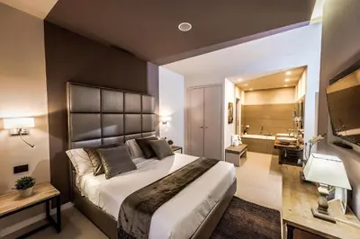 a bedroom with a large bed and a bathroom at Delle Vittorie Luxury Rooms&Suites in Palermo