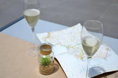 two glasses of wine sitting on a table with a map at B&b Mondello Resort in Palermo