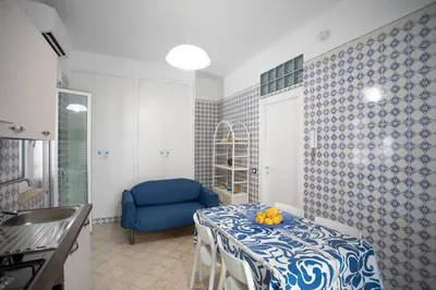 a kitchen with a table and a blue chair at Villa Aurora Mondello Addaura in Mondello