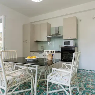 a kitchen with a black table and white chairs at Villa Aurora Mondello Addaura in Mondello