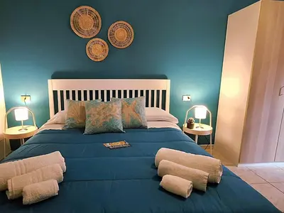 a bedroom with a blue bed with two pillows at Sea Room Aspra in Bagheria