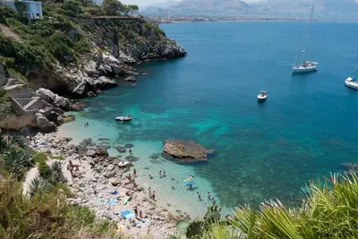 a group of people on a beach in the water at Sea Room Aspra in Bagheria