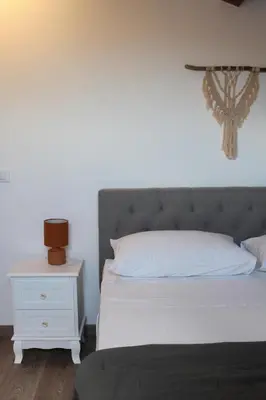 a bedroom with a white bed and a night stand at Mondello Apartment in Mondello