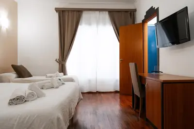 a hotel room with two beds and a flat screen tv at Hotel City Center in Palermo