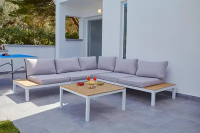 a couch and a coffee table on a patio at Casa del Melograno con idromassaggio e giardino in Terrasini