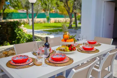 a white table with fruit and wine glasses on it at Casa del Melograno con idromassaggio e giardino in Terrasini