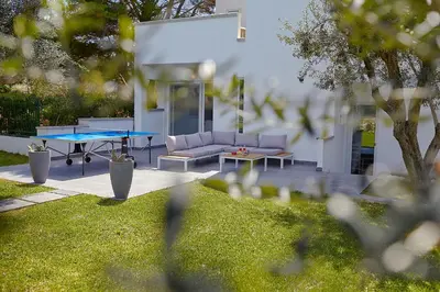 a ping pong table and a couch in a yard at Casa del Melograno con idromassaggio e giardino in Terrasini