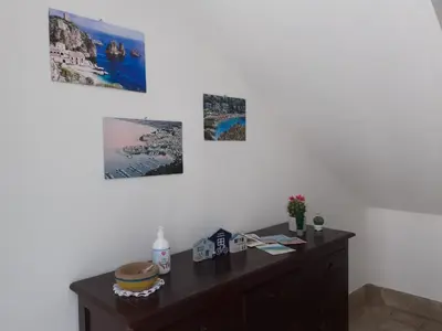 a desk in a room with three pictures on the wall at Duchessa in Castellammare del Golfo