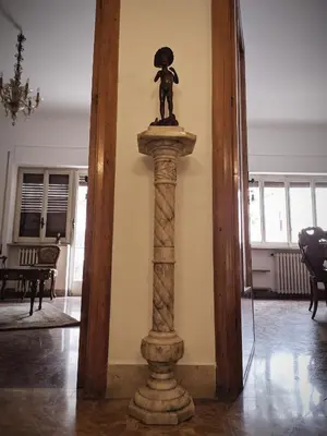 a statue of a girl on a column in a room at Olivarooms in Palermo
