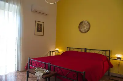a bedroom with a bed with a red blanket on it at Olivarooms in Palermo