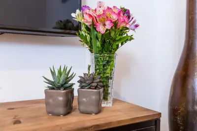 a vase filled with pink flowers on a table at Mosina Apartments in Palermo