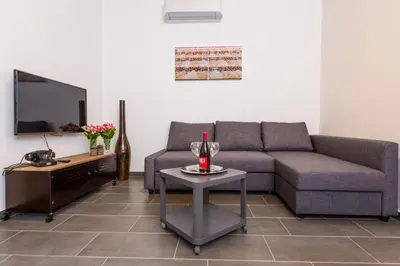 a living room with a couch and a table with a wine glass at Mosina Apartments in Palermo