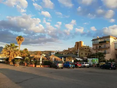 a parking lot with cars parked in front of buildings at Benvenuti al Sud in Trabia
