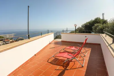 a pair of red chairs sitting on a balcony at Benvenuti al Sud in Trabia