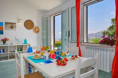 a dining room with a table with food on it at Villa Delfino - Scopello-Villas in Scopello