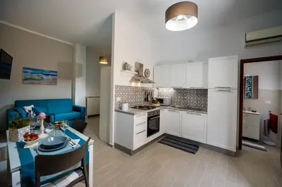 a kitchen and living room with a table and a couch at Annina'S Home Panoramic sea view By Sicily Home Solutions in Castellammare del Golfo
