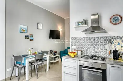 a kitchen with a stove and a table with chairs at Annina'S Home Panoramic sea view By Sicily Home Solutions in Castellammare del Golfo