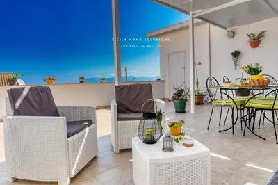 a patio with a table and chairs and an umbrella at Annina'S Home Panoramic sea view By Sicily Home Solutions in Castellammare del Golfo