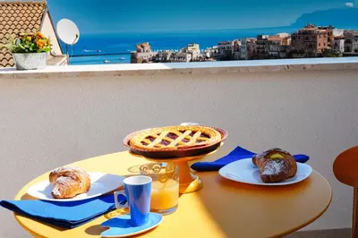 a table with a waffle and pastries on it at Annina'S Home Panoramic sea view By Sicily Home Solutions in Castellammare del Golfo