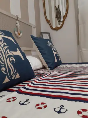 a bed with blue and white sheets and pillows at Finestra Azzurra in San Vito lo Capo