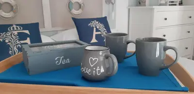 three coffee mugs and a box on a table at Finestra Azzurra in San Vito lo Capo
