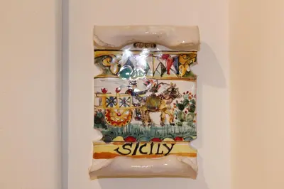 a shelf with a painting ofiety on a wall at cocciu d'amuri in Caccamo